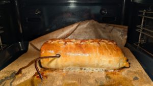 Beef Wellington baking in the oven with a probe thermometer cable