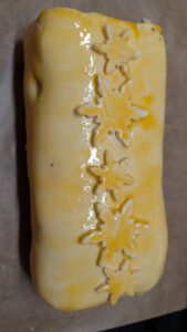 Pastry-wrapped Beef Wellington brushed with egg yolk and decorated with snowflake cut-outs