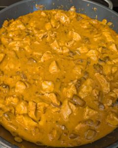 Skillet of creamy paprika-orange chicken stroganoff sauce with mushrooms